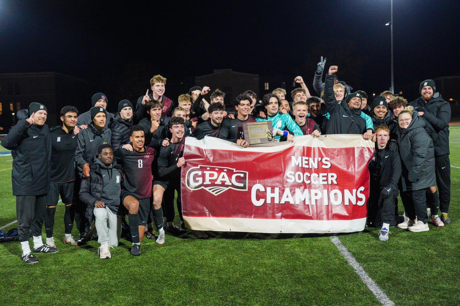 Sports Dynasty Spieler feiern den GPAC Men's Soccer Championship Titel
